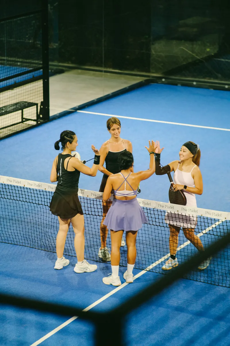 Four players high-fiving at the net