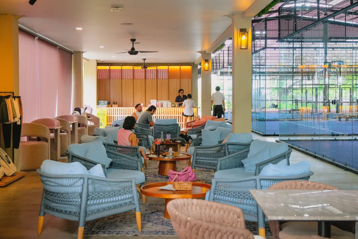 Lounge chairs in front of reception, looking onto the courts